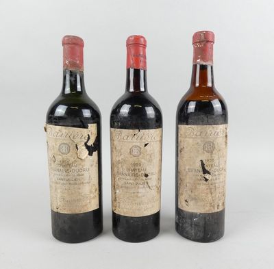 trois bouteilles de vin sont posées côte à côte sur une surface blanche
