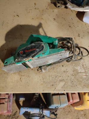two pictures of a green circular saw on the floor