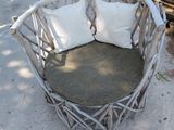 a chair made out of sticks with pillows on top of it