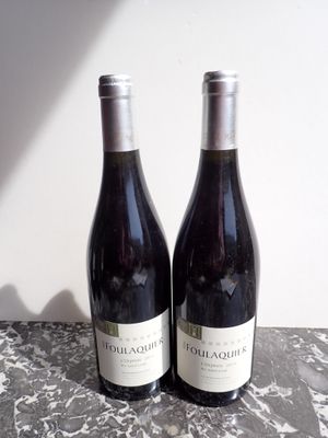 two bottles of red wine sitting on a table