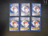 six pokemon keychains in plastic packaging on a table