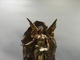 statue en bronze représentant une femme ailée posée sur un rocher