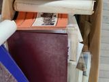 a box full of books and a pen sitting on the floor