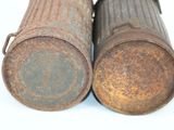 two old rusty canisters sitting next to each other on a white surface