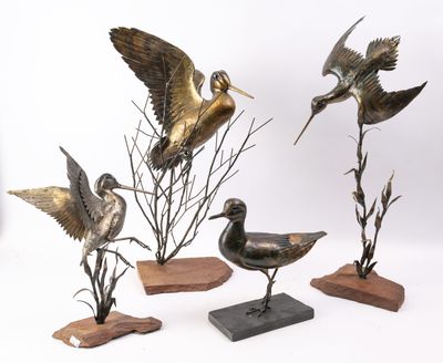 trois statues d'oiseaux en bronze posées sur des socles en bois, sur un fond blanc