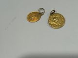 a close up of two gold coins on a white surface