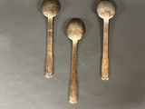 three spoons and a spoon rest on top of a table