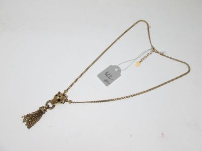 gros plan d'un collier sur une surface blanche avec une étiquette