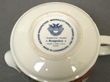 a white cup with a blue and white design on it
