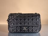 black chanel bag on table with reflection on surface