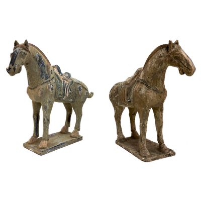 Deux statues de chevaux se dressent l'une à côté de l'autre sur une surface blanche