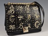 un sac à main noir et doré, orné de clous dorés et d'une chaîne