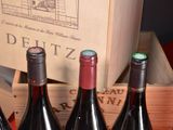 several bottles of wine sit in a wooden crate on a table