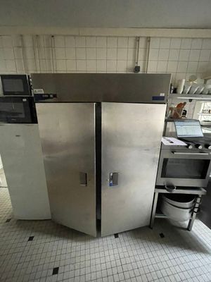 une image d'une cuisine avec un réfrigérateur et un évier