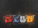 trois pichets de couleurs différentes posés sur une surface noire