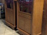 two tall wooden cabinets with glass doors in a room