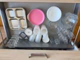 a drawer that has a bunch of empty dishes and cups in it