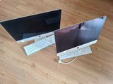 two computers sitting side by side on a wooden floor