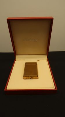 an image of a gold lighter in a red box on a table