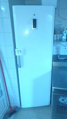 a white refrigerator in a small kitchen with a trash can