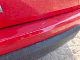 a close up of a red car with a sticker on it ' s bumper