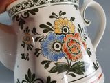 a person holding a coffee cup with a floral design