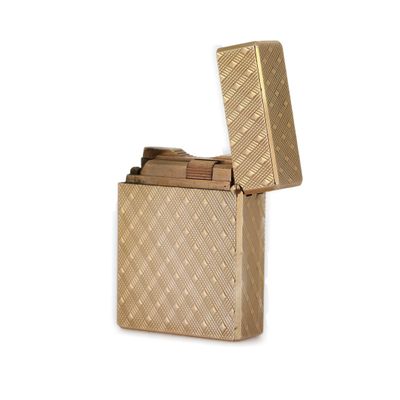 un briquet doré posé sur une surface blanche