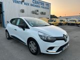 une voiture blanche garée devant un immeuble, avec d'autres voitures en arrière-plan