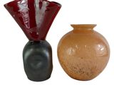 deux vases posés l'un à côté de l'autre sur une surface blanche