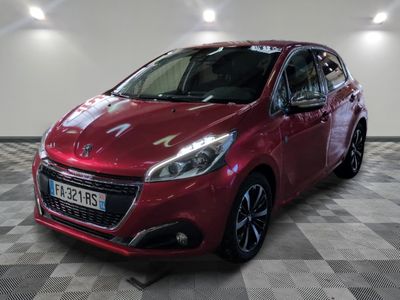 la voiture rouge est garée sur un sol en damier dans le garage