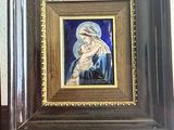 a painting of a woman holding a child on a easel
