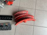 a red object on the floor next to a remote control