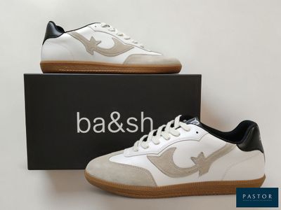a pair of white and black sneakers sitting on top of a box