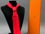 un mannequin portant une cravate rouge et tenant une boîte orange