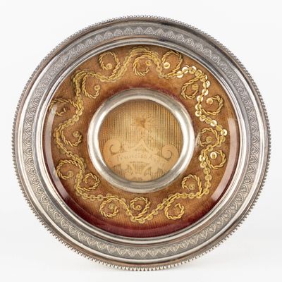 a silver and gold plate with a picture on it