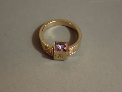 une bague en or sertie d'une pierre rose
