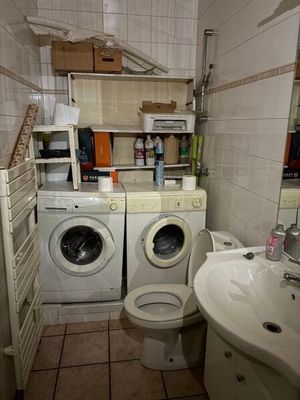 une machine à laver et des toilettes dans une petite salle de bains