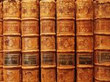a lot of old books that are on a shelf