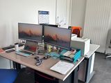 un bureau avec deux ordinateurs et une chaise dans la chambre