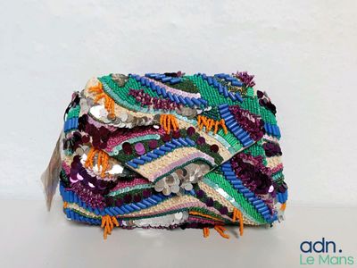 un sac à main multicolore posé sur une table blanche