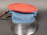 a small hat with a red and blue patch on top of it