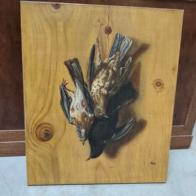 un tableau représentant un oiseau mort accroché à un mur