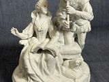figurine représentant un homme et une femme assis sur une chaise