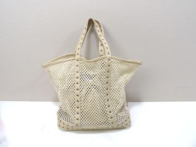 beige crocheted tote bag on a white table