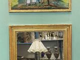 deux tableaux accrochés au mur d'une pièce où se trouve une lampe