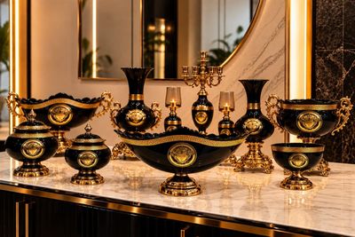 a lot of black and gold vases sitting on a table