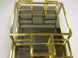 a gold metal and glass display case on a white background