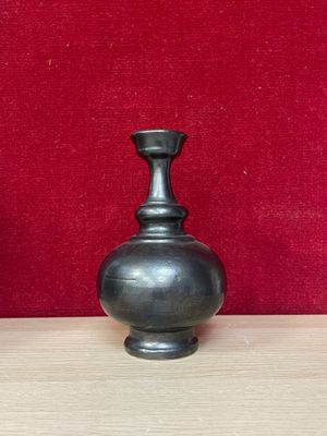 two vases sitting on a table with a red wall in the background