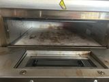 a metal oven that has a dirty pan inside of it
