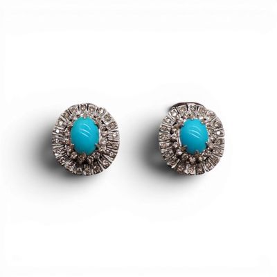 une paire de boucles d'oreilles en turquoise et diamants sur fond blanc